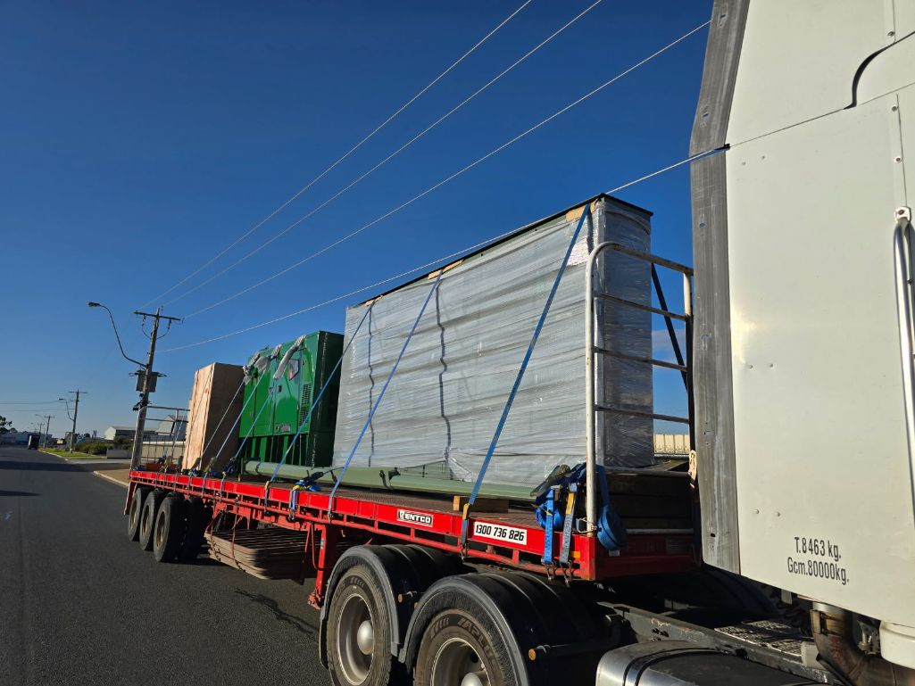 A Semi Truck is Driving Down a Road With Boxes on the Back of It — Goulburn Transport In Sydney, NSW