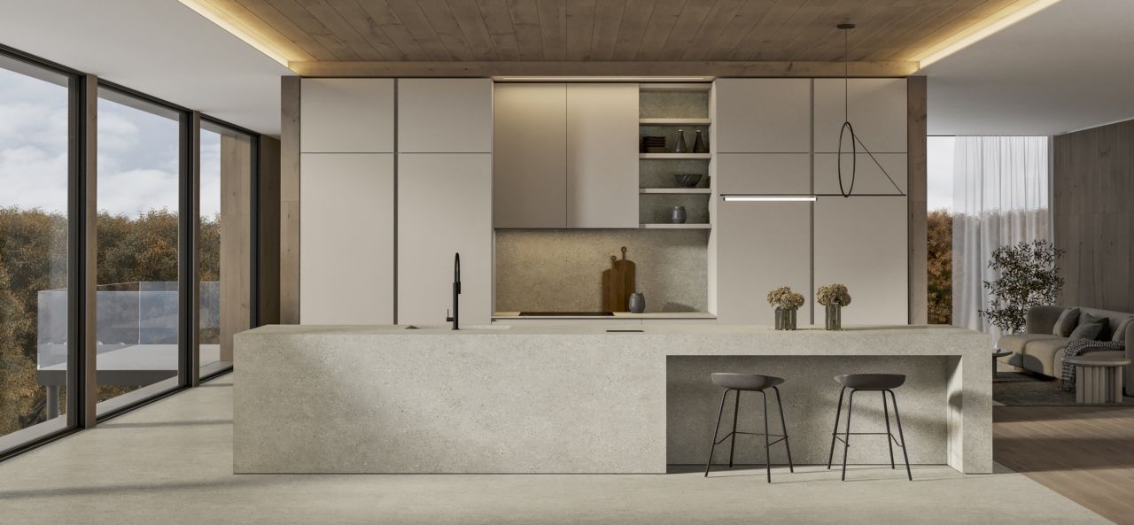 Cucina moderna e minimalista con un'ampia isola centrale, armadi a muro e vetrate a tutta altezza con vista sul lago.