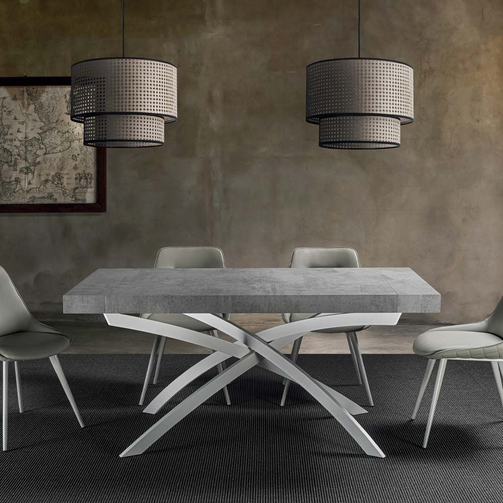 Sala da pranzo moderna con tavolo grigio, sedie bianche e due lampade a sospensione intrecciate.