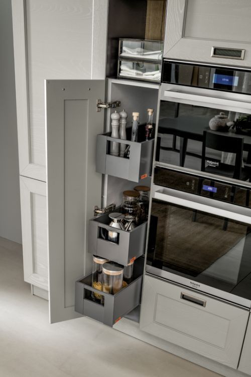 Porta spezie estraibile accanto a un forno a incasso in acciaio inox in una cucina moderna.
