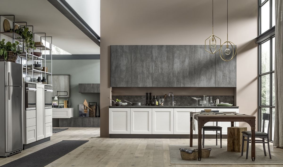 Cucina moderna a vista con zona pranzo, ampie finestre, mobili in legno e un tavolino con sedie.