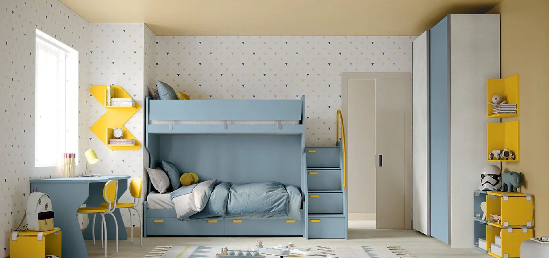 Luminosa cameretta per bambini con letto a castello blu, dettagli gialli, scrivania, mensole e grande finestra.
