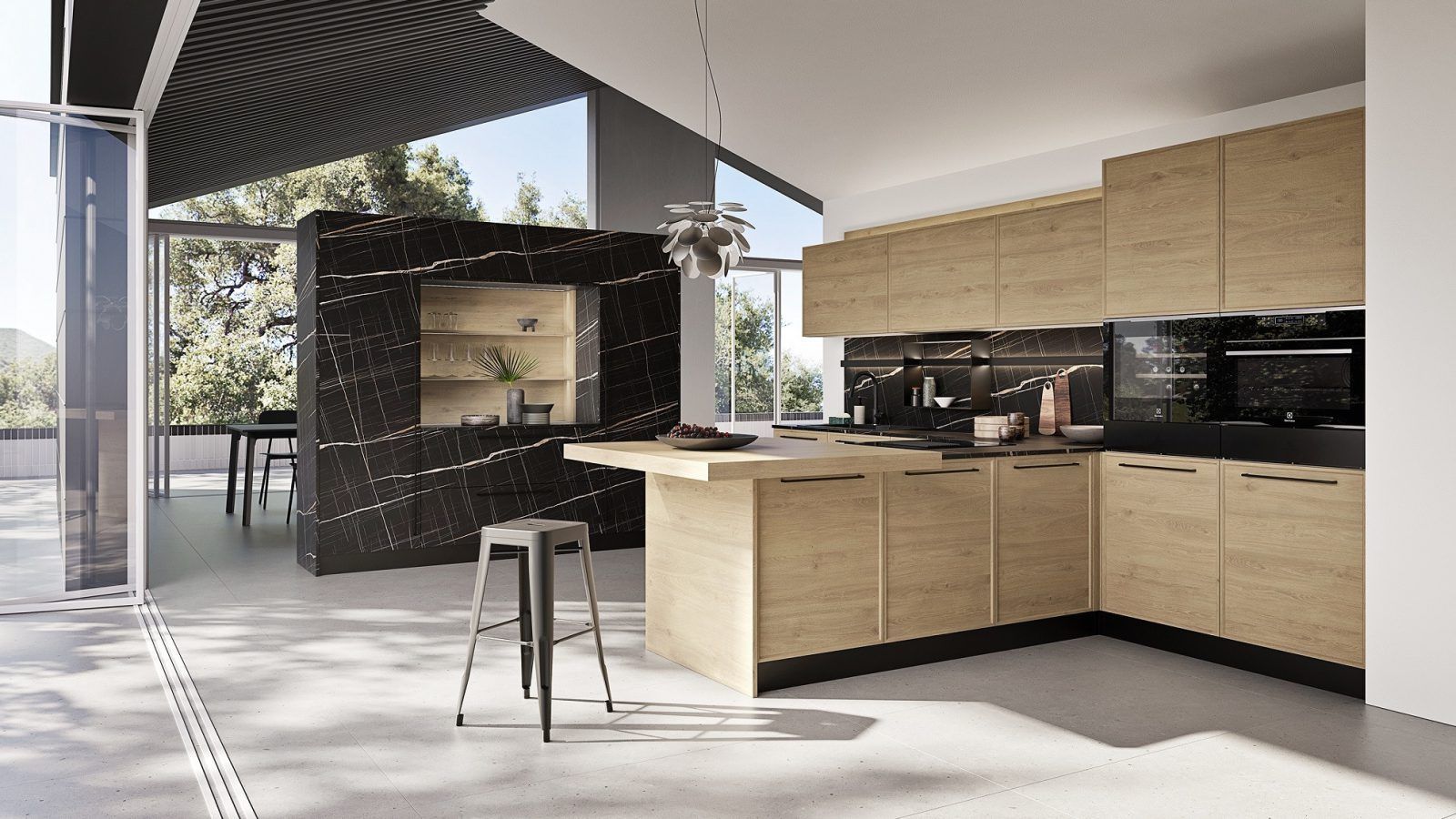Cucina moderna a pianta aperta con mobili in legno chiaro, sgabelli sull'isola e zona pranzo esterna coperta.