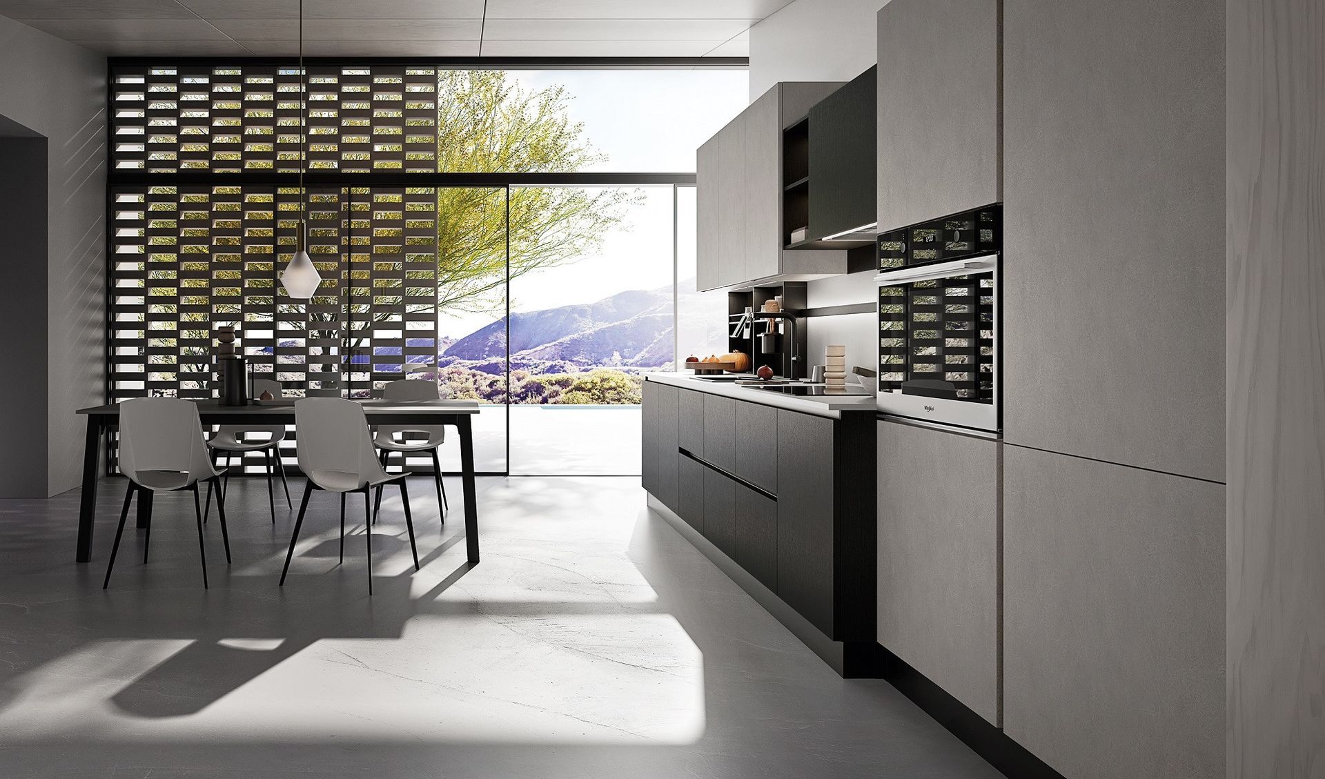 Cucina moderna con tavolo da pranzo, luce naturale e vista sulle montagne attraverso ampie porte finestre.