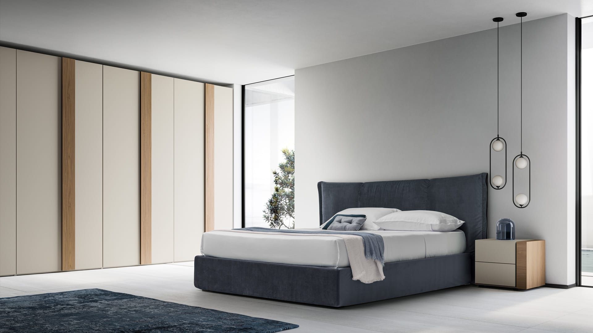Camera da letto moderna e minimalista con letto grigio, pareti neutre e pannelli armadio a tutta altezza.