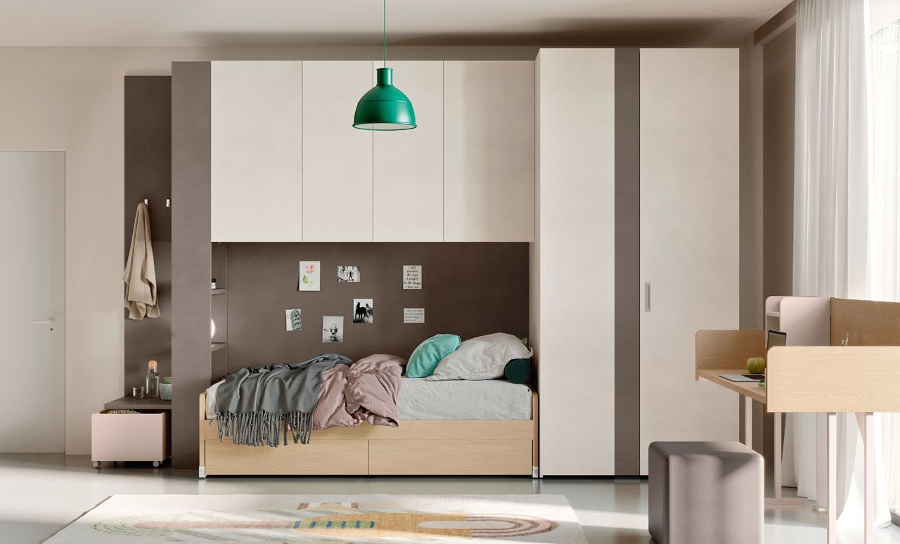Camera da letto moderna con letto, lampada a sospensione verde, armadi a muro e scrivania accanto a una finestra luminosa.
