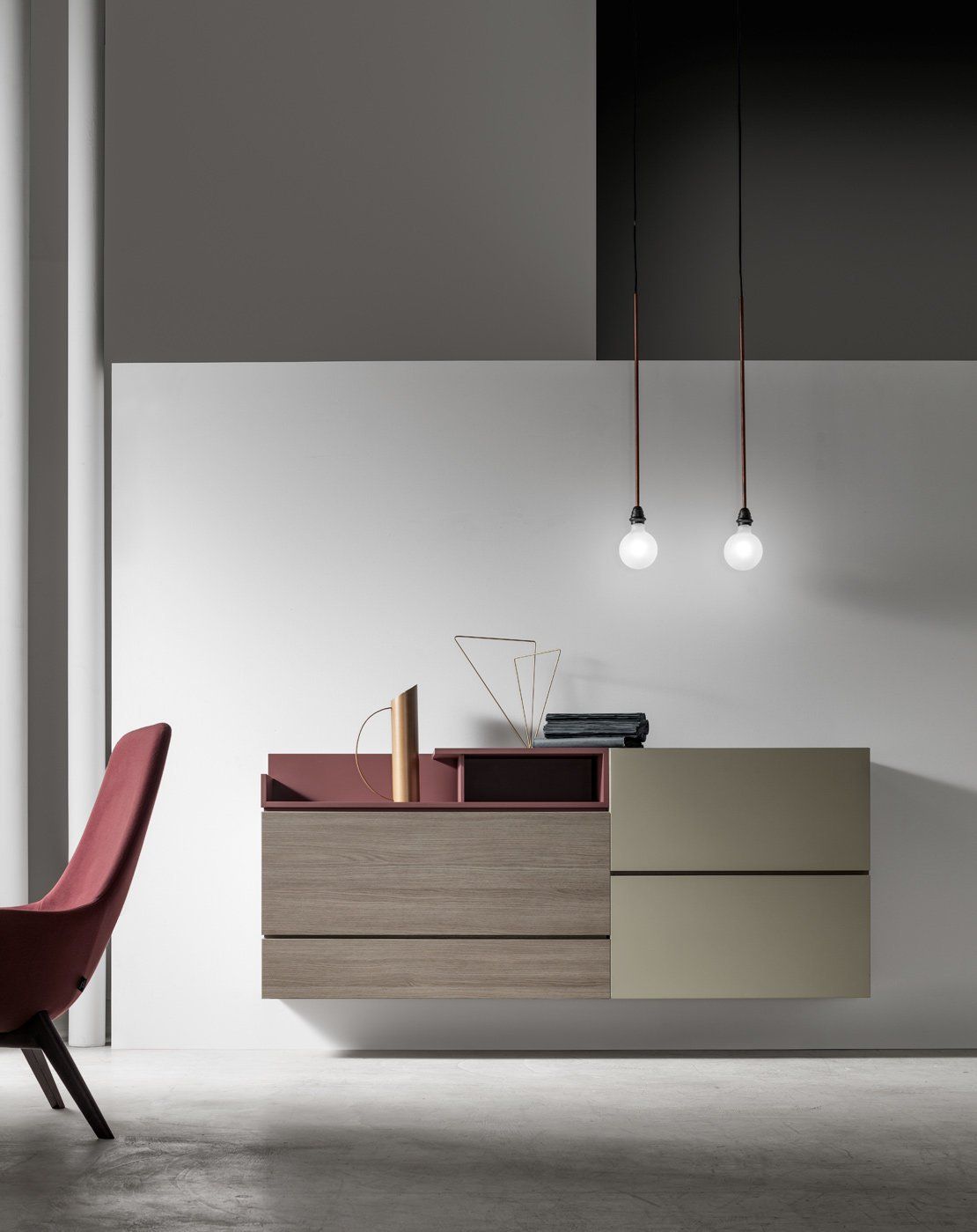 Sala da pranzo moderna e minimalista con lampade a sospensione e una credenza bicolore accanto a una sedia rossa.