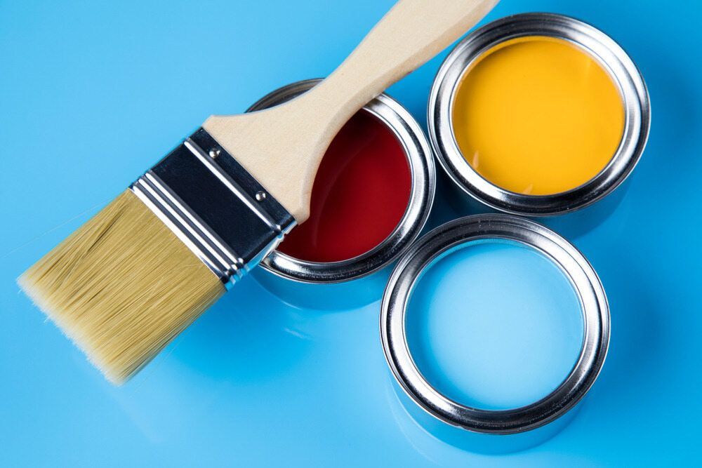Three Cans Of Paint And A Brush On A Blue Surface — Heness Painting In Park Avenue, QLD