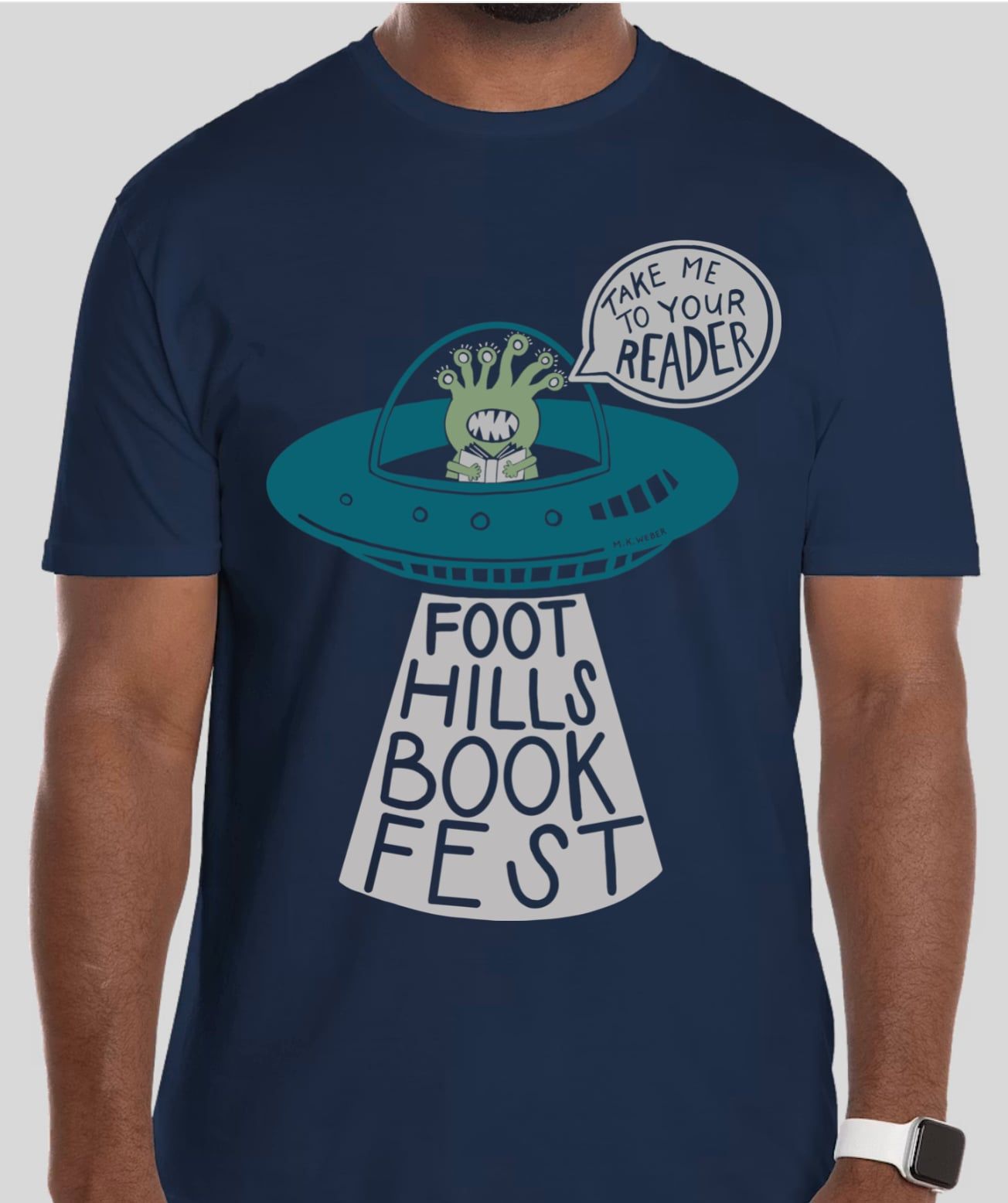 Navy T-shirt with a Foot Hills Book Fest graphic and a speech bubble saying “Take me to your reader”