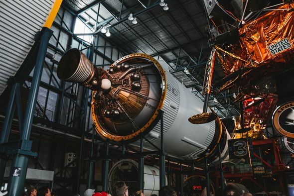 A group of people are looking at a space shuttle in a hangar.