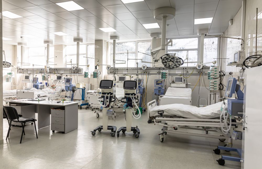 A hospital room with a lot of beds and medical equipment.