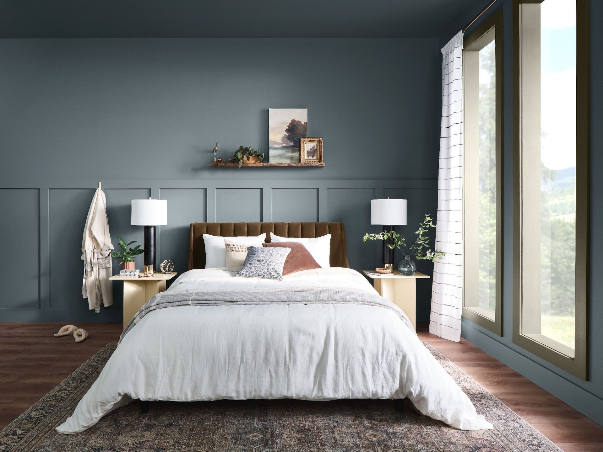 Bedroom with blue-gray walls, a bed with white bedding, and large window with view.