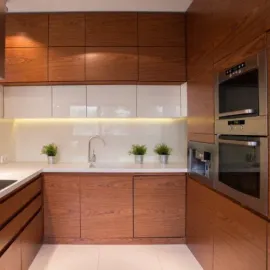 Modern kitchen with wooden cabinets, white backsplash, and built-in appliances.