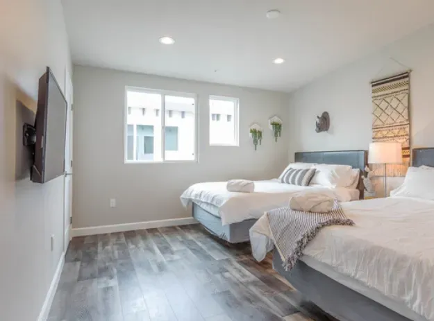 A bedroom with two beds and a flat screen tv.