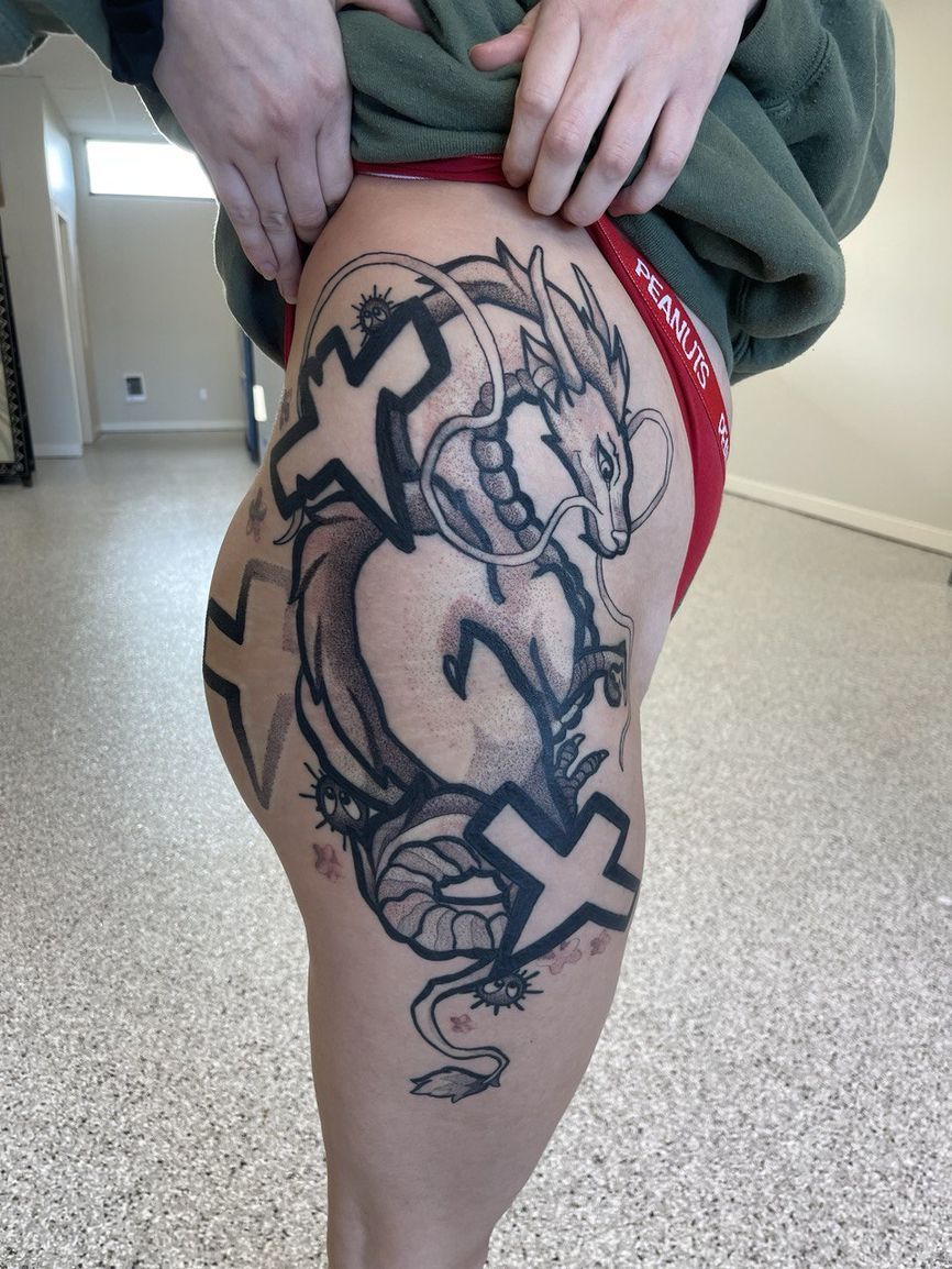 A woman has a tattoo of a dragon on her leg