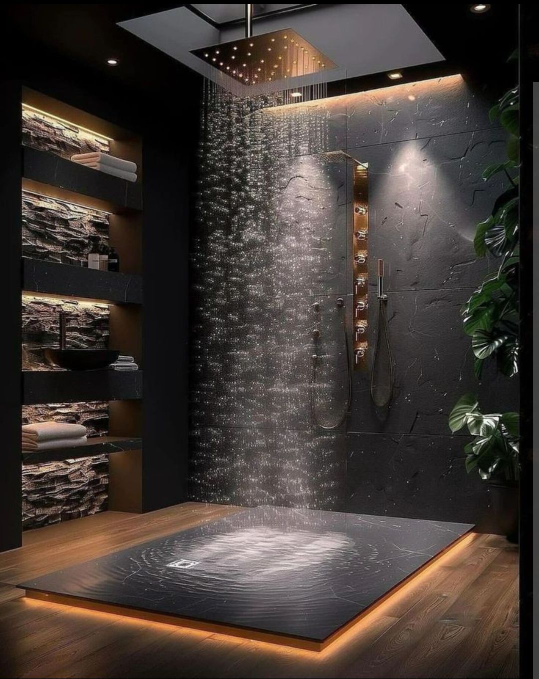 Modern black shower with cascading water, warm wood flooring, and dim recessed lighting.
