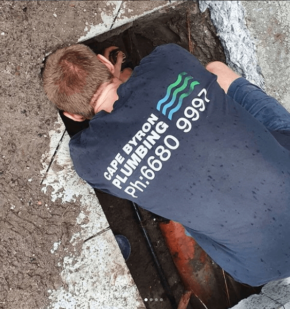A man putting his hands in a trench hole - Byron Bay plumbing, cape byron plumbing