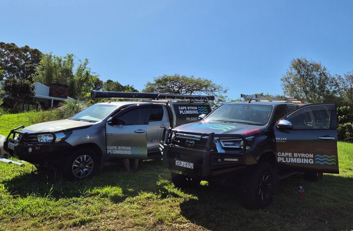 Two company trucks are parked next to each other — Cape Byron Plumbing in Byron Bay, NSW