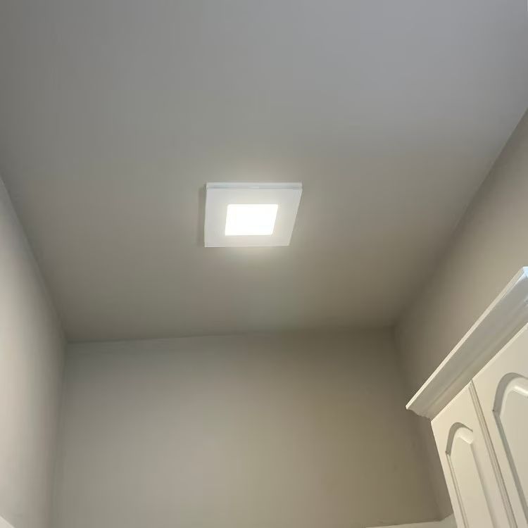 Plain white ceiling with a square recessed light in a small room corner