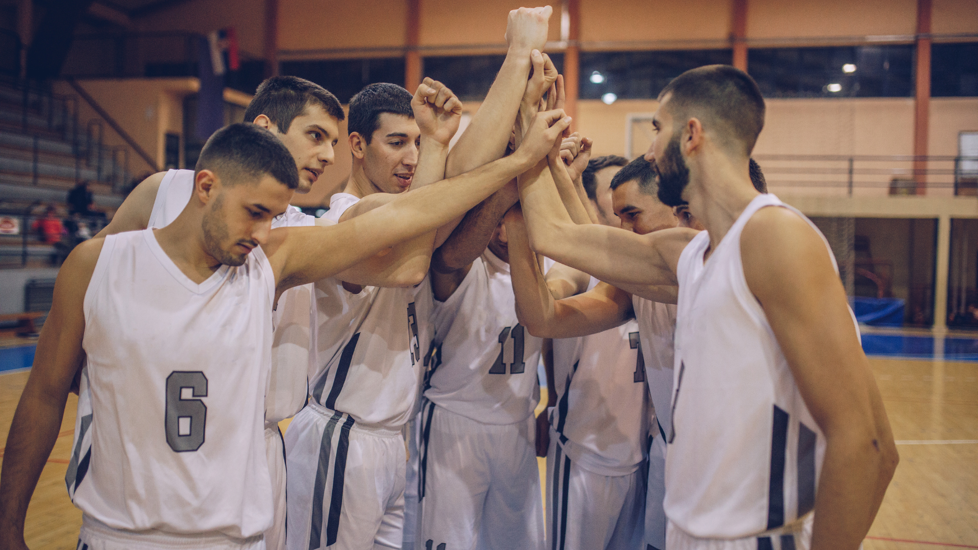 A group of basketball players are huddled together on a court.