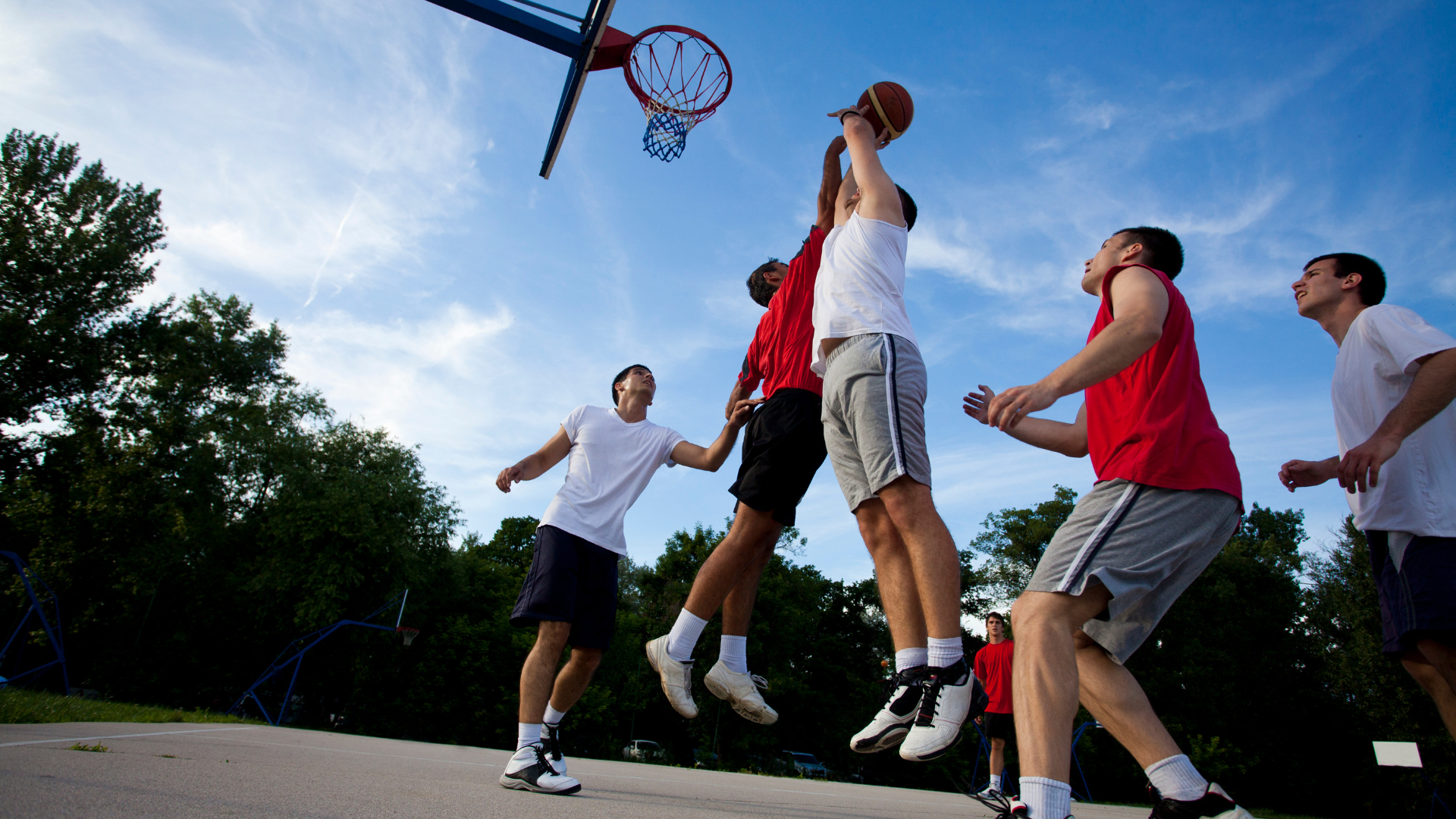 A group of young men are playing basketball on a court