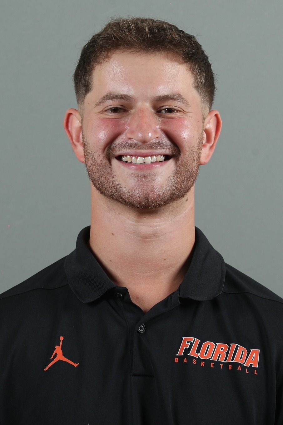 A man with a beard is wearing a black polo shirt with the word florida on it.