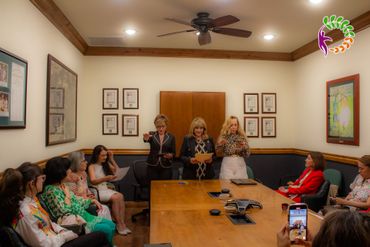 Un grupo de mujeres está sentada alrededor de una mesa en una sala de conferencias.