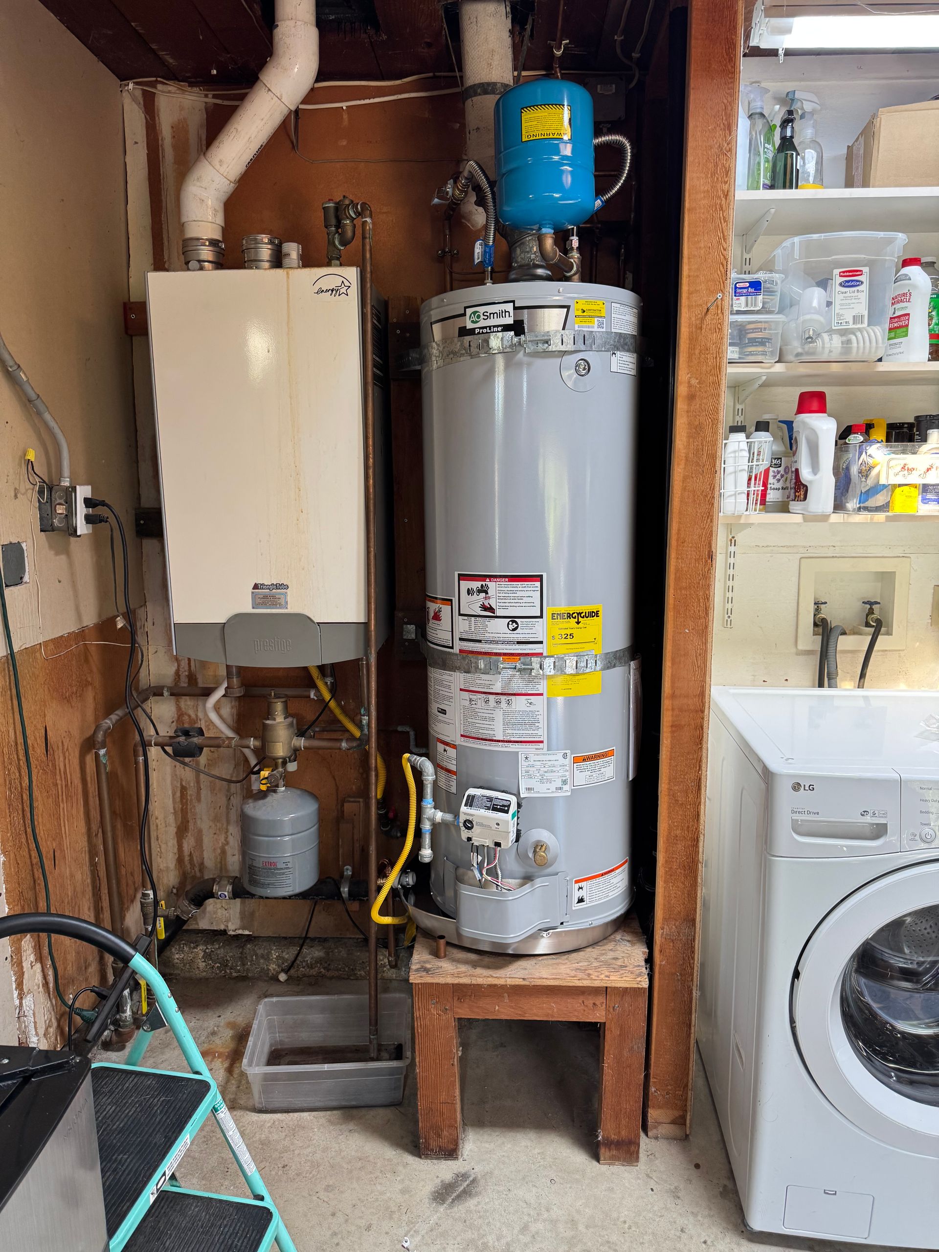 Utility closet with water heater, furnace, and washing machine in a cramped basement space