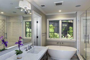 A bathroom with a tub , sink , and mirror.