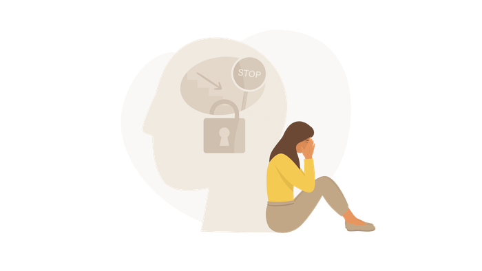 Woman sitting with hands covering face; mind represented with a lock and word “STOP.”