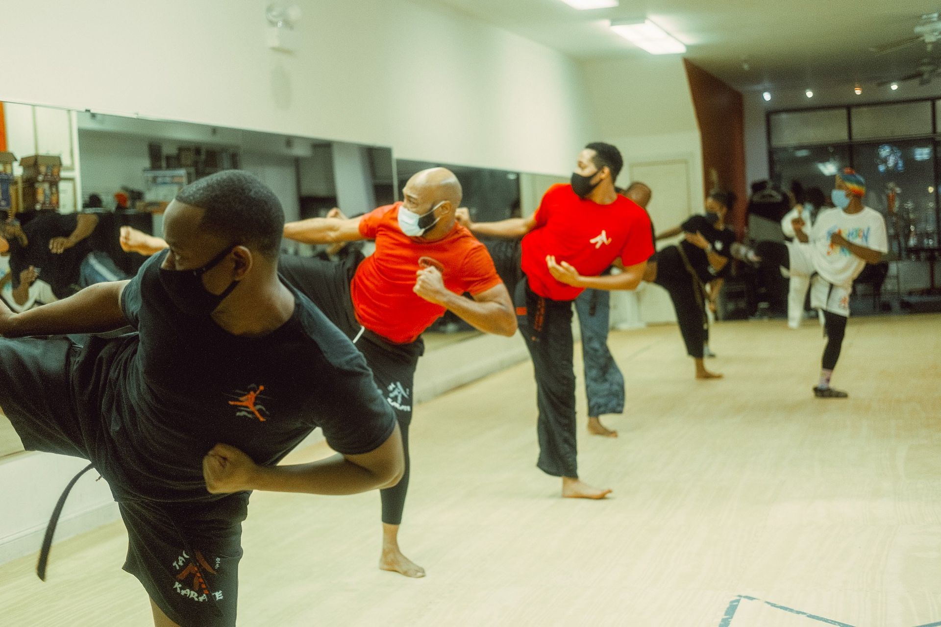 A group of people are practicing martial arts in a gym.