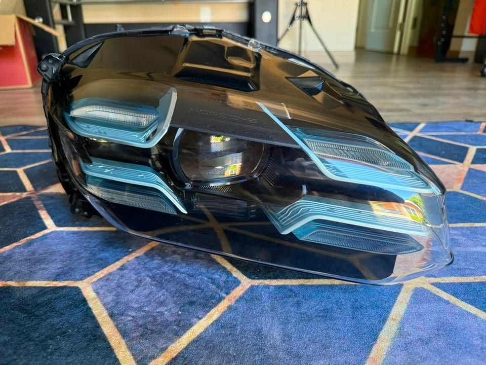 Black futuristic sports car model on a blue patterned rug indoors