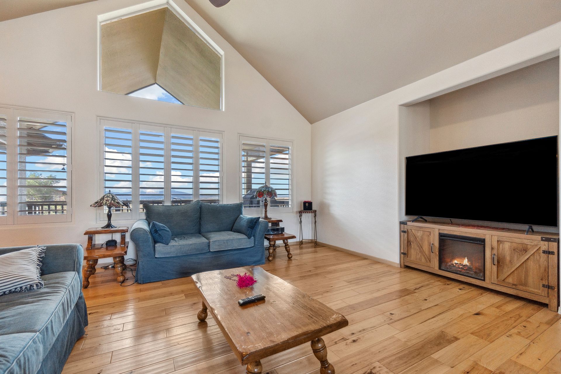 A cosy living room with modern decor and natural light from interior shutters.