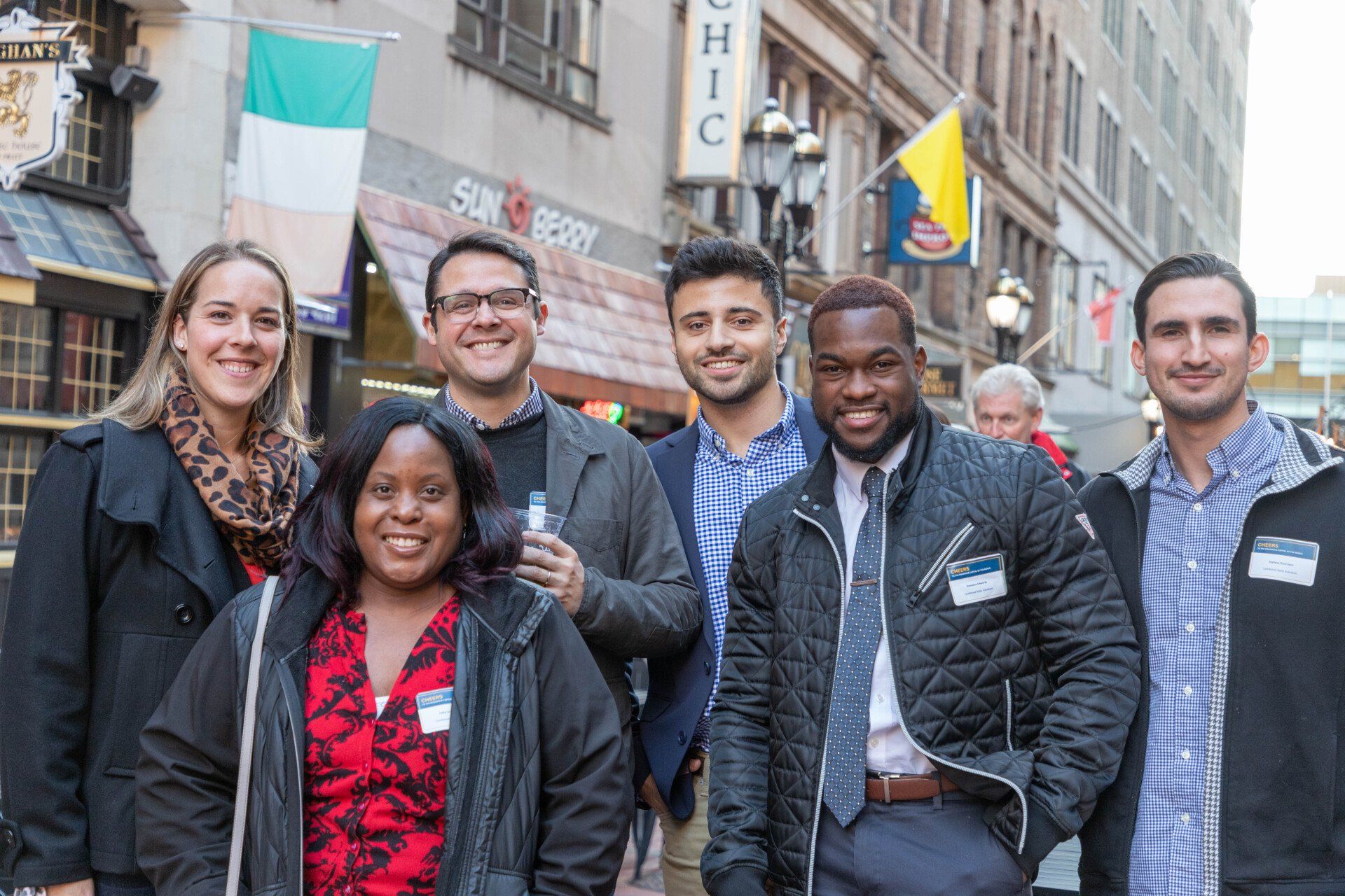 A group of people are posing for a picture on a city street.