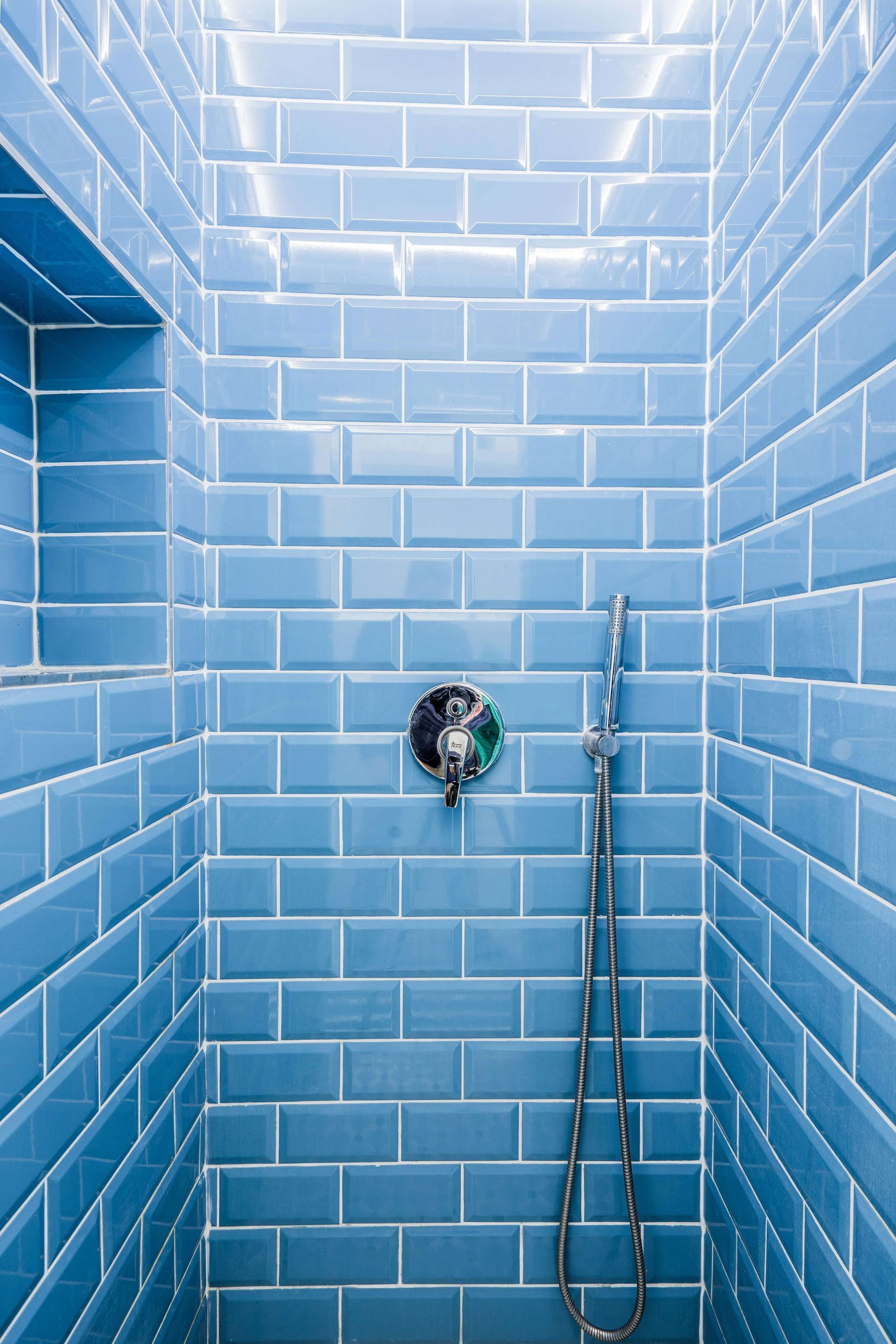 This is an image of a bathroom tiling project that consists of blue shiny tiles