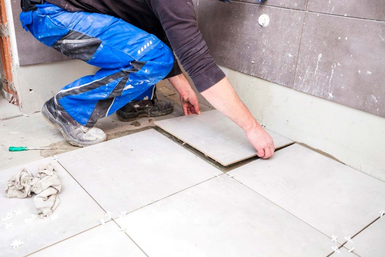 This is an image of a worker replacing large tile
