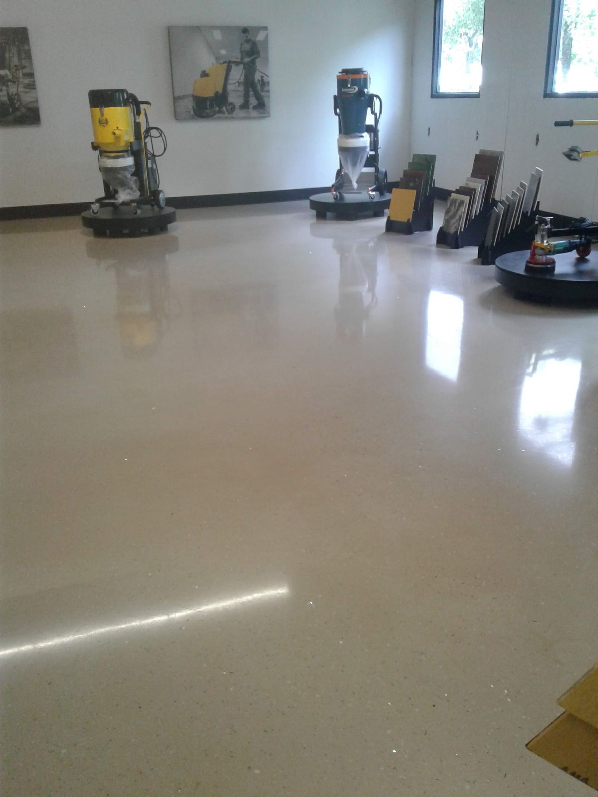 Polished showroom floor with several floor-cleaning machines and equipment along the walls