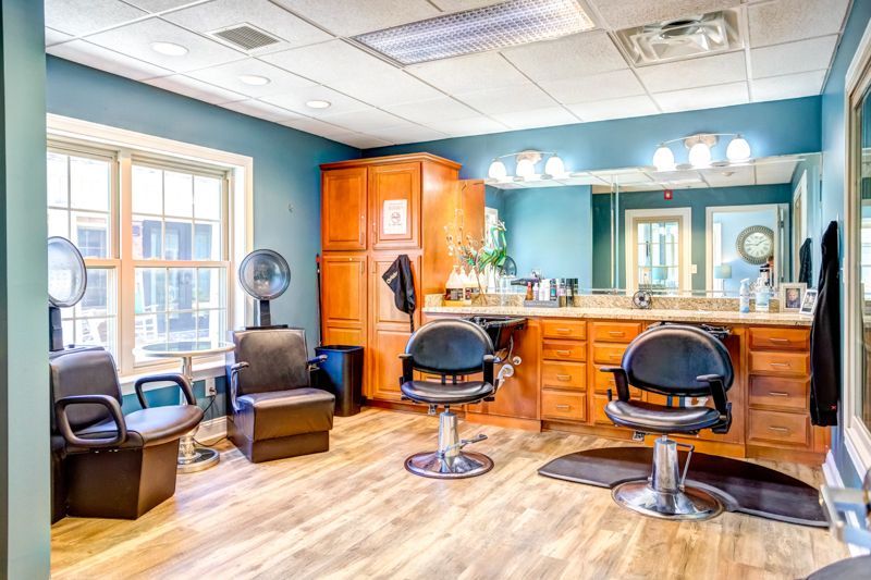 A hair salon with a lot of chairs and a mirror.