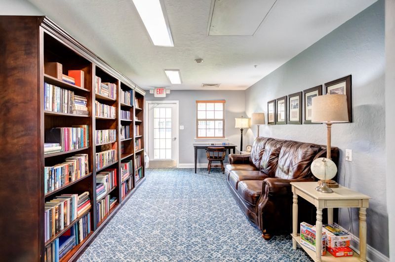 A long hallway filled with bookshelves and a couch.