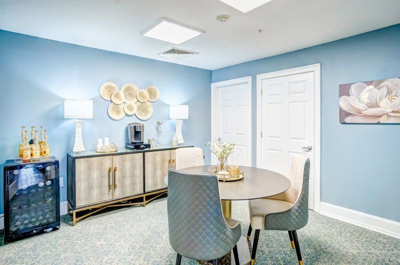 A dining room with a table and chairs and a wine cooler.