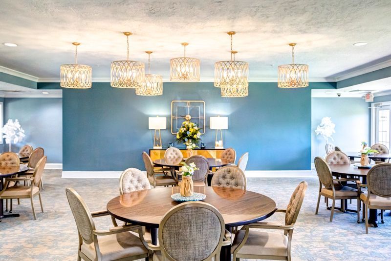 A large dining room with tables and chairs and a blue wall.