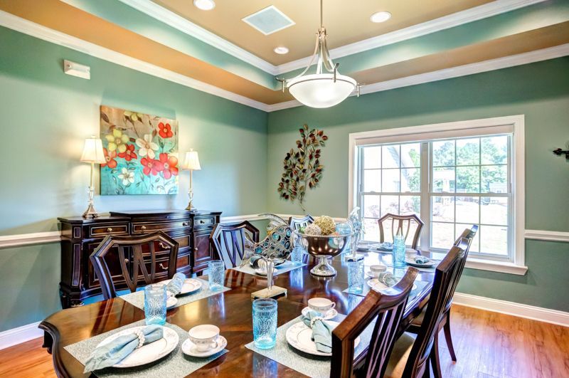 A dining room with a long table and chairs set for a meal.