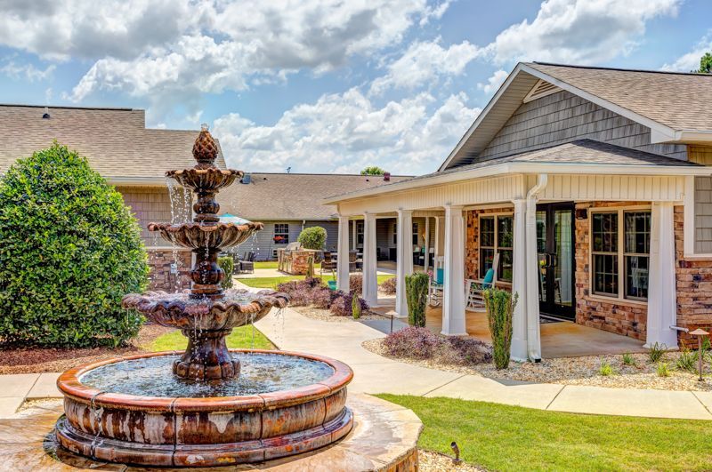 There is a fountain in front of a house.