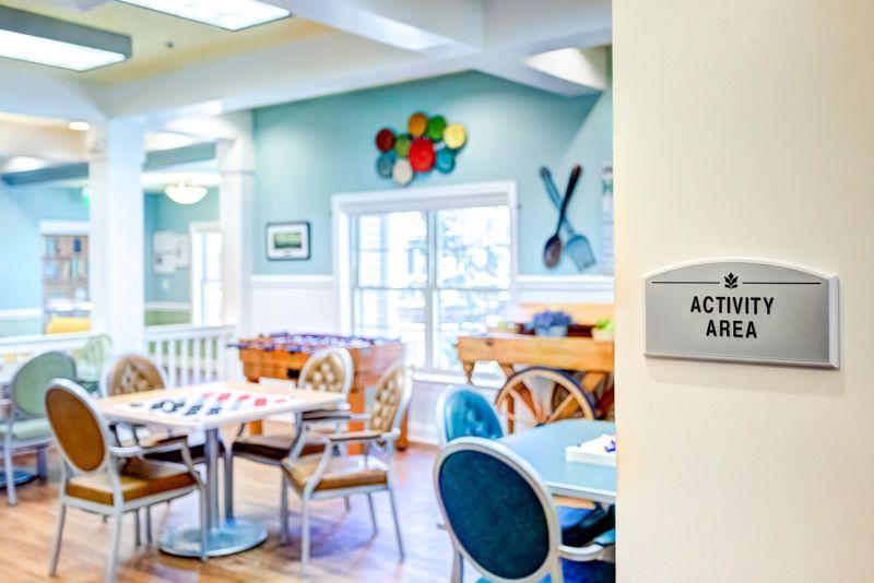 A room with tables and chairs and a sign that says activity area.