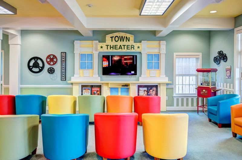 A room with colorful chairs and a tv that says town theater