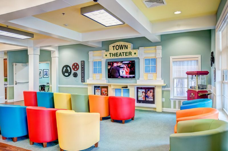 A room with a lot of colorful chairs and a television.