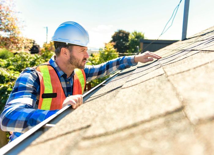 Professional Roof Inspector Inspecting Residential Roof