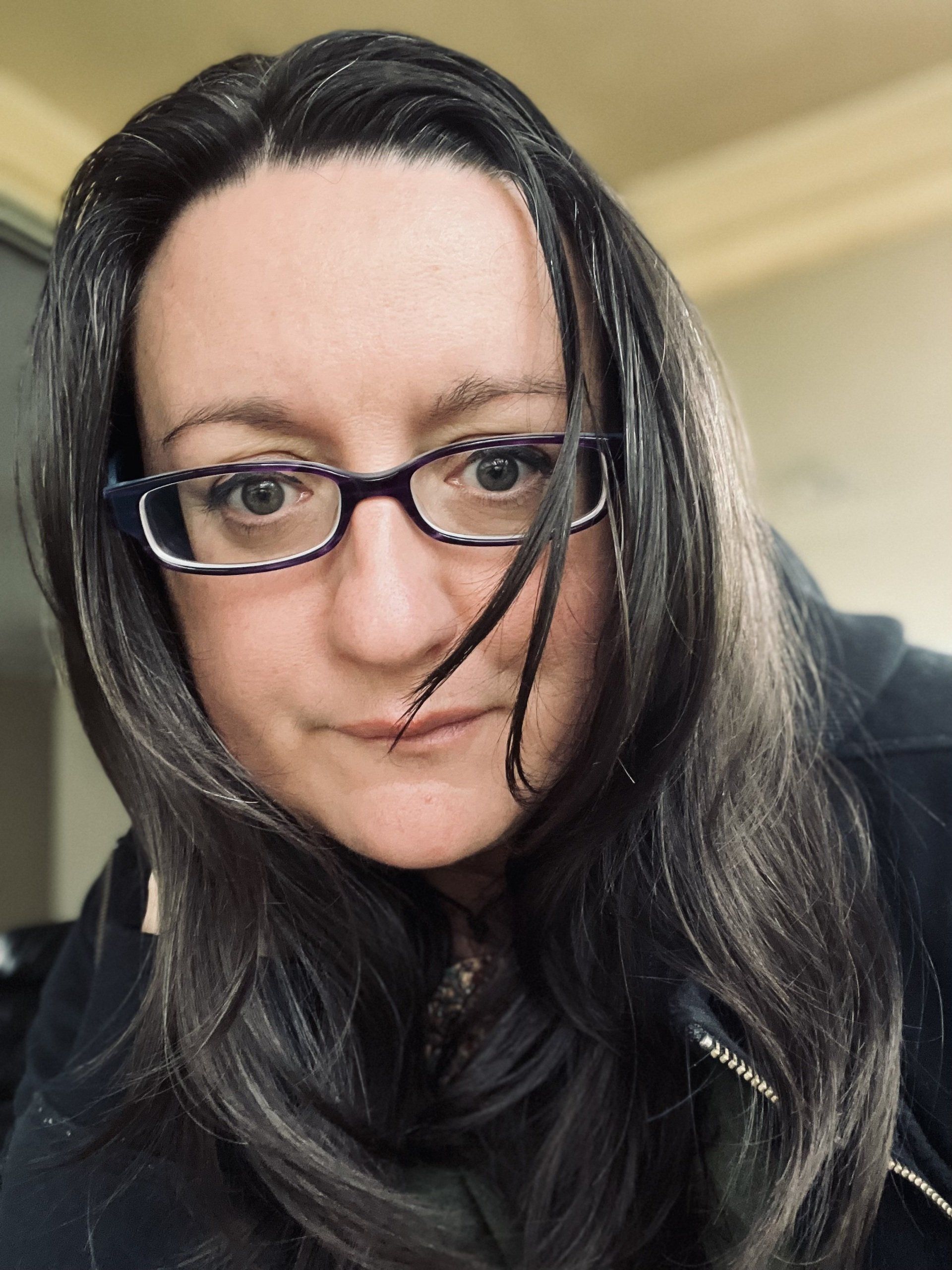 A close up of a woman wearing glasses and a black shirt