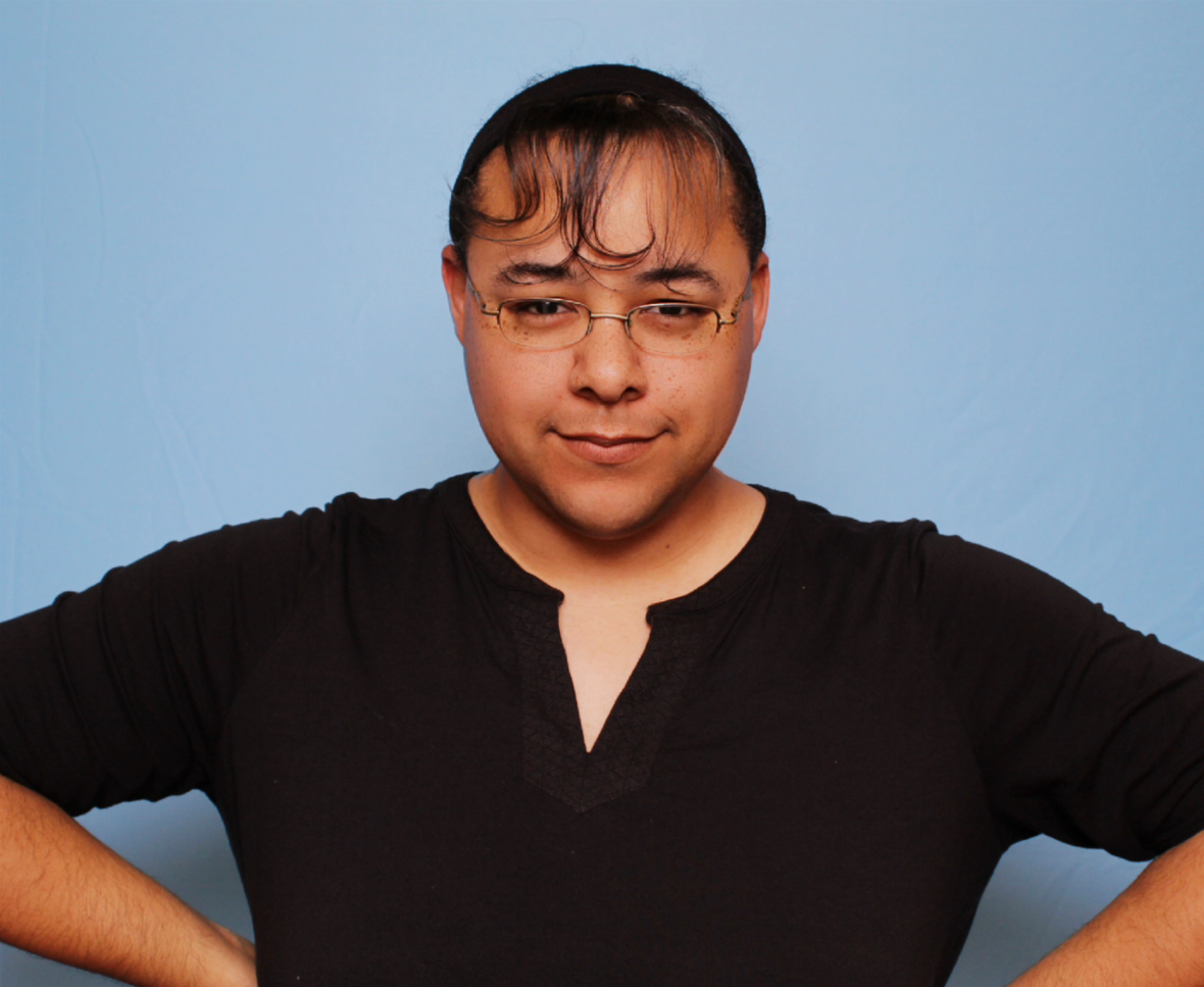 A man wearing glasses and a black shirt has his hands on his hips