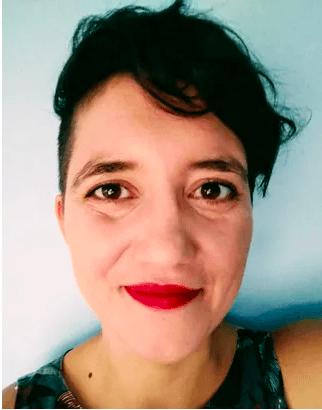 A woman with short hair and red lipstick is smiling for the camera.